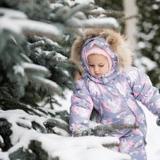 Två tjejer leker i snö med vinteroverall på sig.