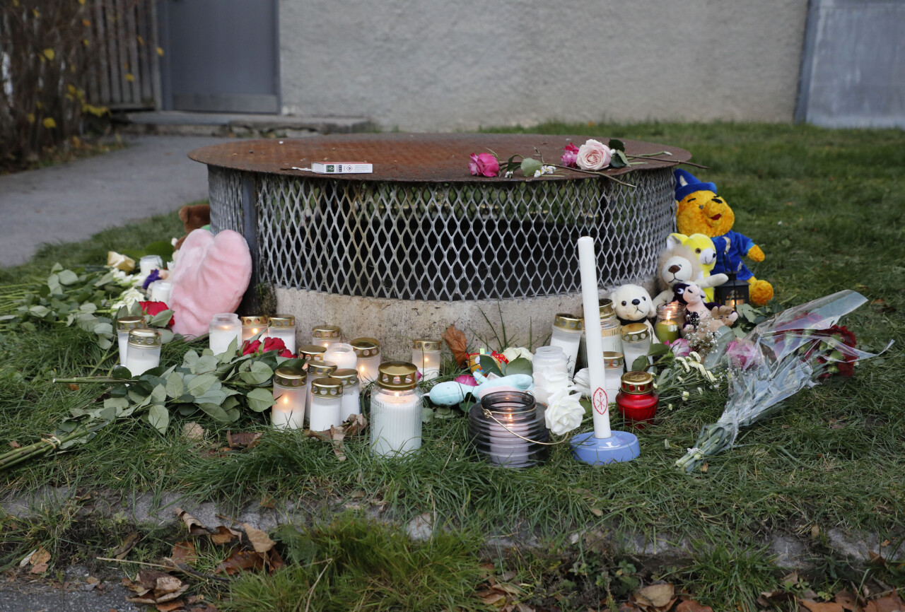 Gosedjur, blommor och ljus har lagts ner vid den plats där två barn hittades med livshotande skador utanför ett bostadshus i Hässelby i går kväll. Ett av barnen har avlidit av sina skador. Tillståndet för det andra barnet är fortfarande allvarligt.